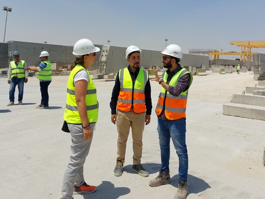 Auf der Baustelle in Ägypten tragen alle eine gelb-orange oder gelbe Leuchtweste sowie einen Helm, links im BIld Simone Stürwald.