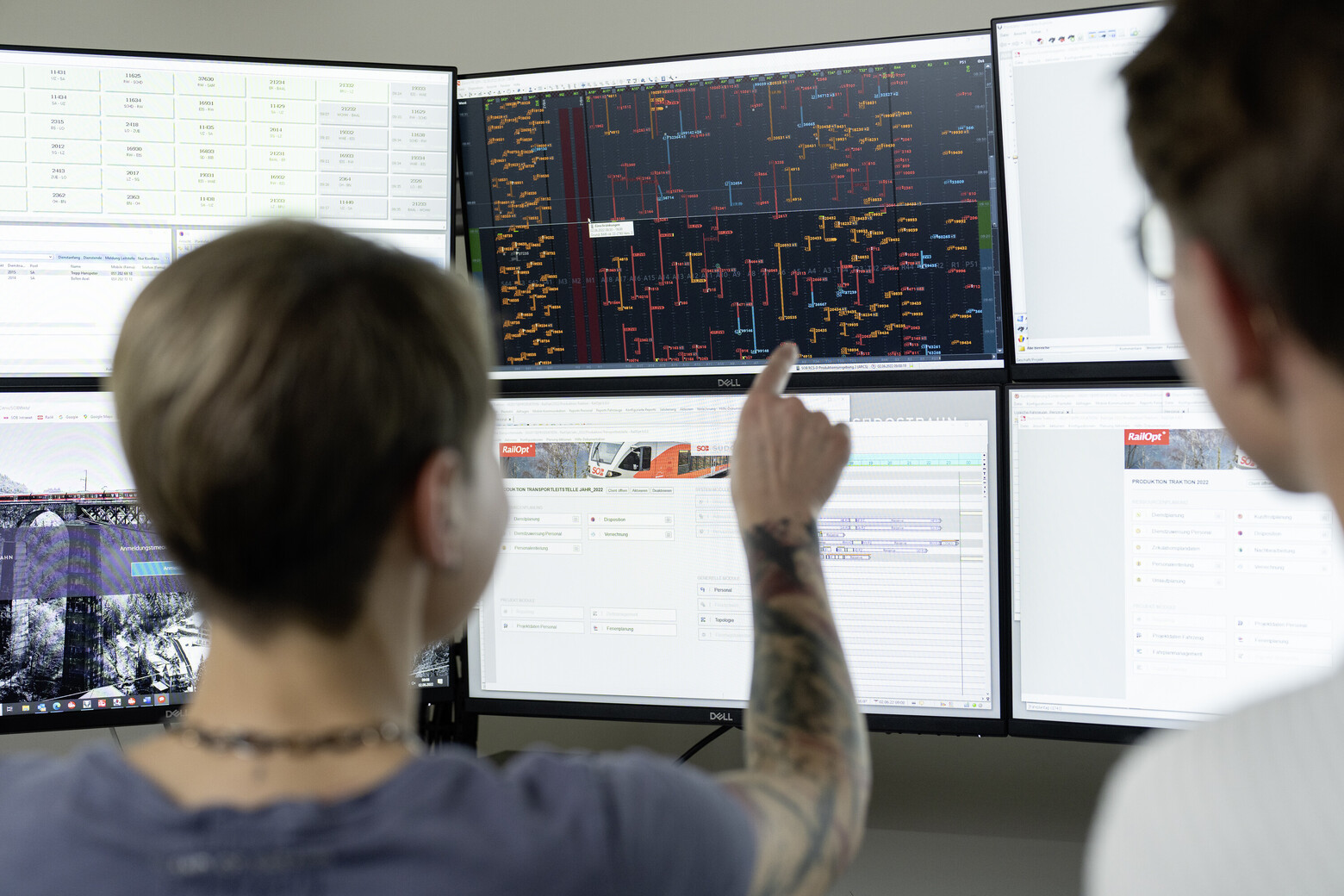  In der SOB-Betriebszentrale in Herisau zeigt eine Person auf einen der sechs Bildschirme. Zu sehen ist jedes Gleis, jede Weiche und jedes Fahrzeug, das auf dem Schienennetz verkehrt.