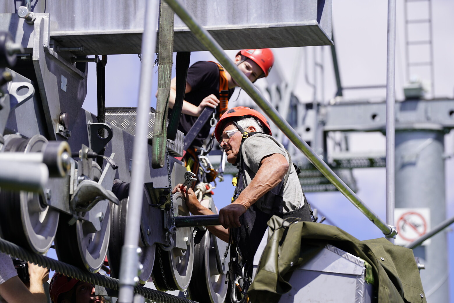 In einer kleinen Gruppe aus Technikern werden die Rollenbatterien der Seilbahn der Revision unterzogen.
