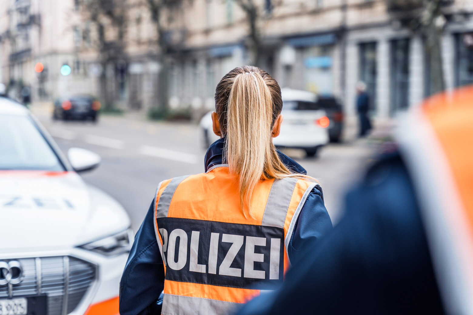 Eine Polizistin schaut sich den Verkehr an und die Kamera fängt den Moment von hinten ein.