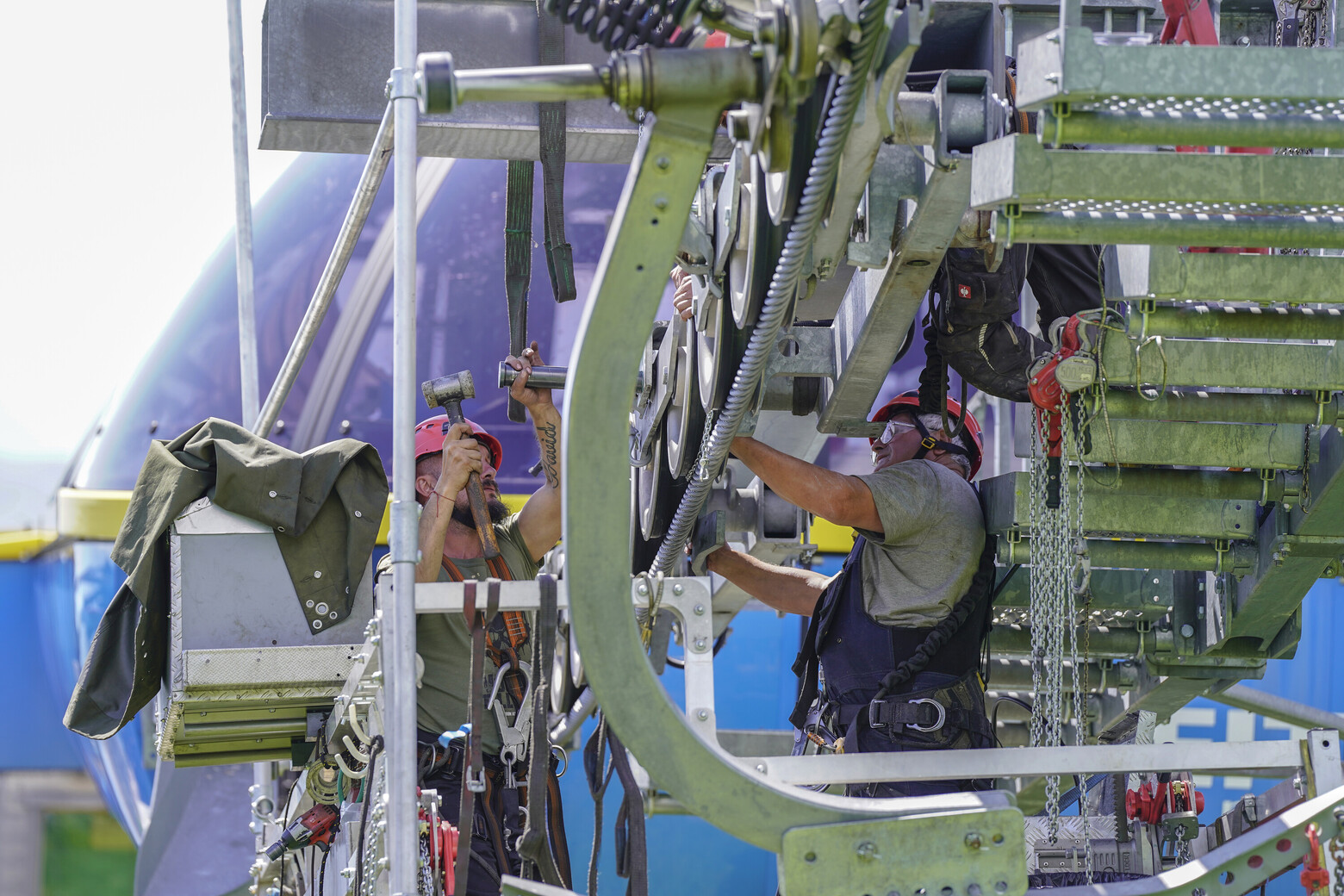 Gesichert auf einer schwebenden Plattform machen, sich die Seilbahntechniker ans Werk.