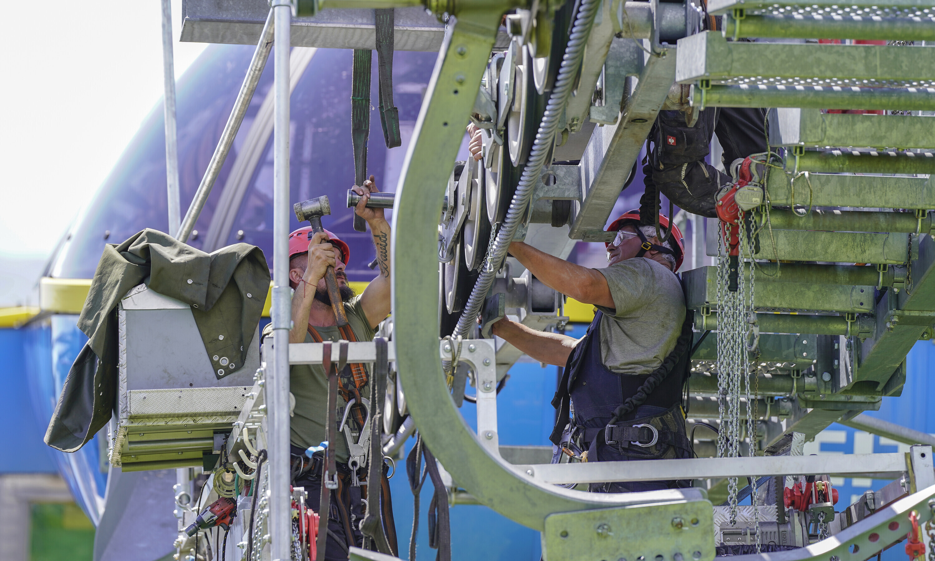 Gesichert auf einer schwebenden Plattform machen, sich die Seilbahntechniker ans Werk.