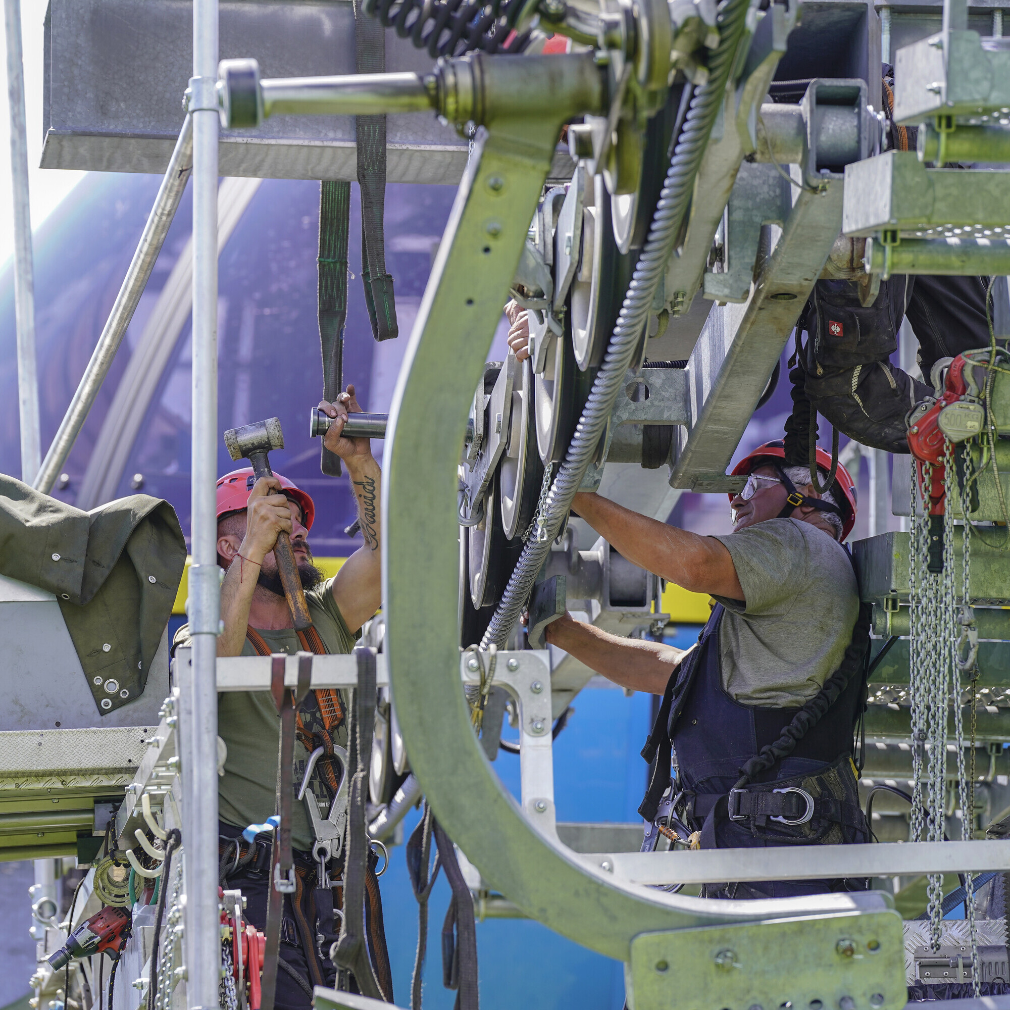 Gesichert auf einer schwebenden Plattform machen, sich die Seilbahntechniker ans Werk.