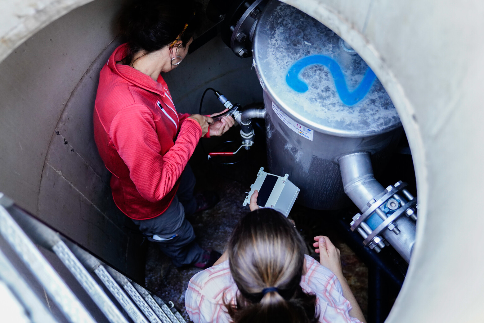 In einem Grundwasserbrunnen installieren die Schwestern Daniela und Jeannette Lippuner Monitoring-Geräte.