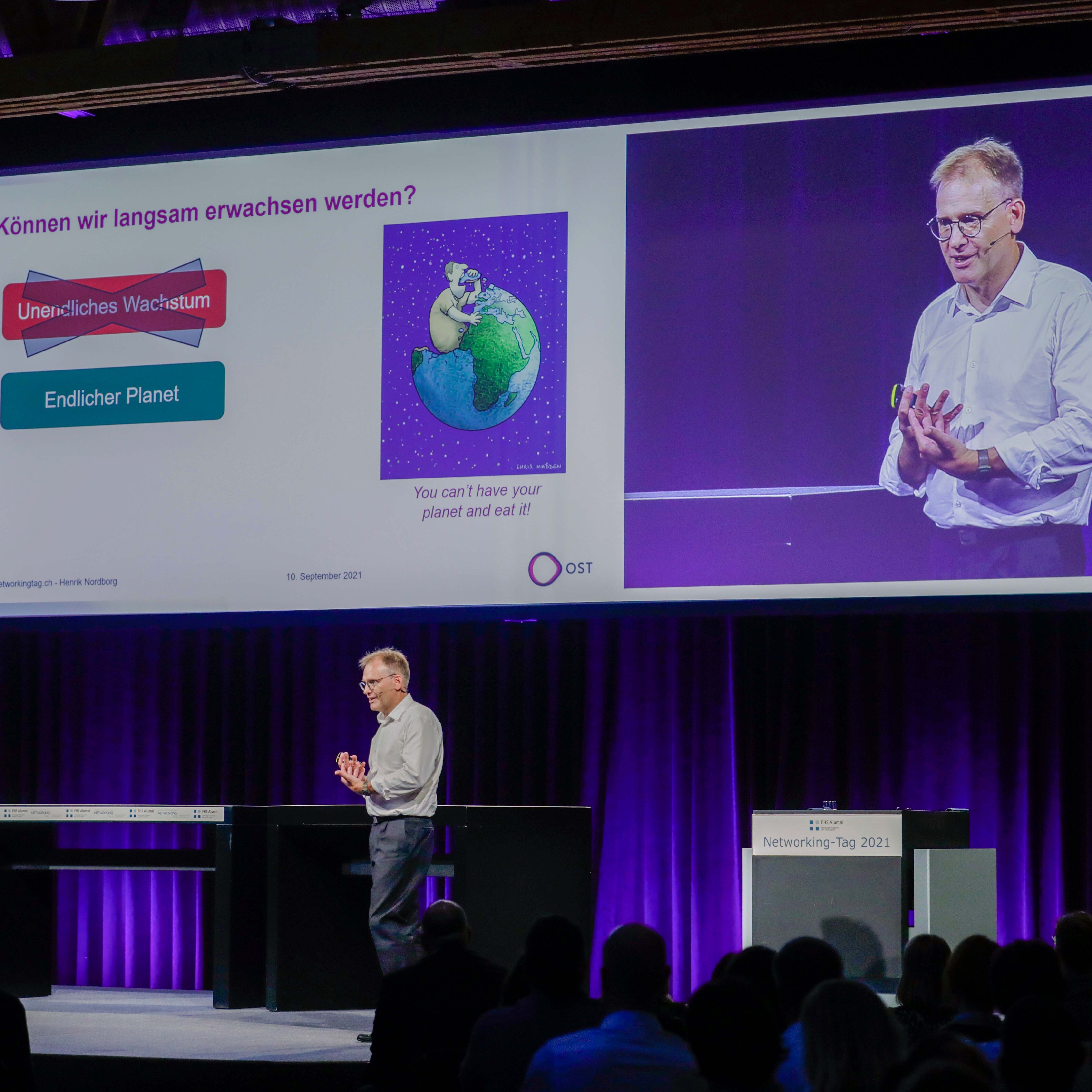 Auf der Bühne steht Prof. Dr. Henrik Nordborg, der Leiter des Studiengangs BSc Erneuerbare Energien und Umwelttechnik, und hält ein Referat.