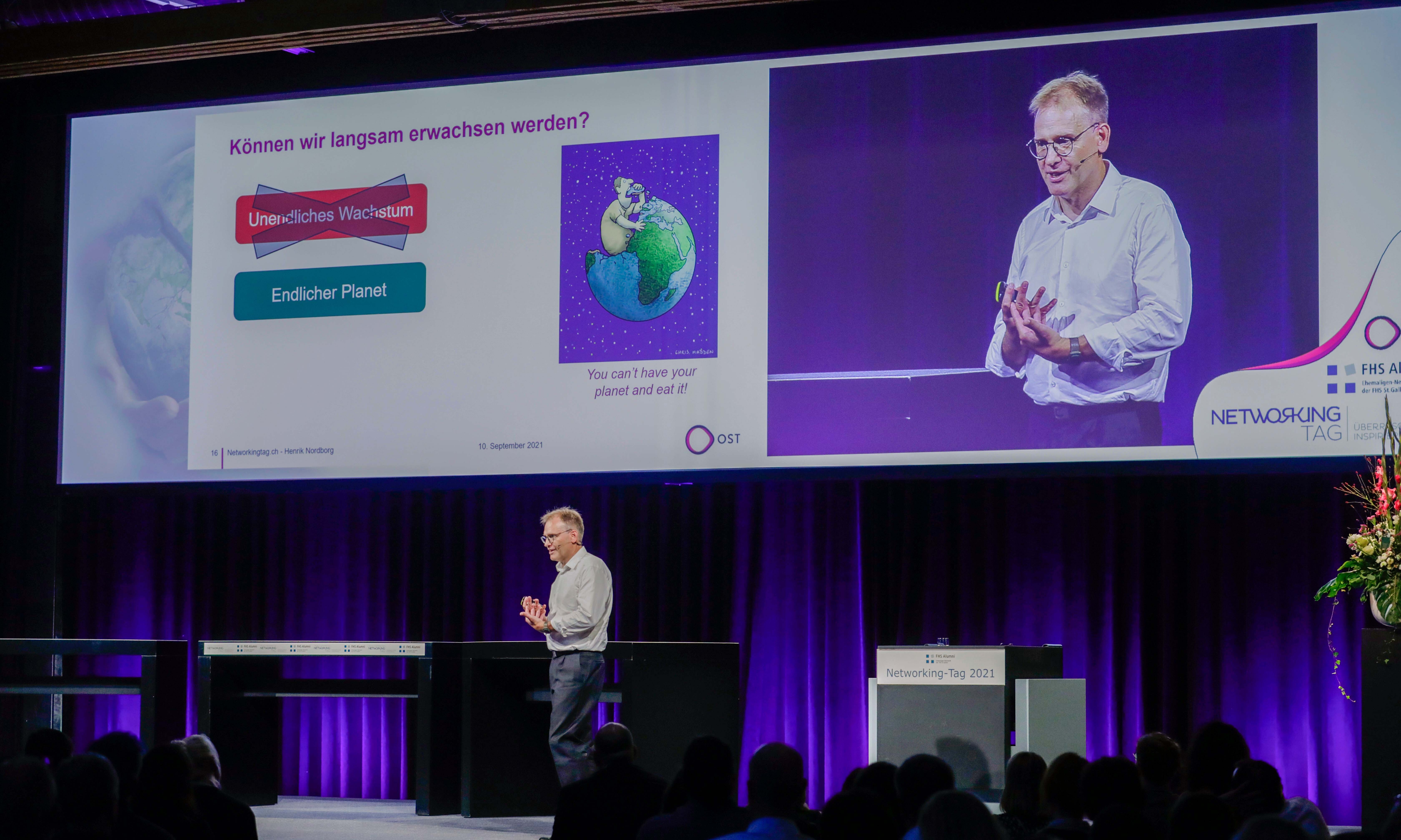 Auf der Bühne steht Prof. Dr. Henrik Nordborg, der Leiter des Studiengangs BSc Erneuerbare Energien und Umwelttechnik, und hält ein Referat.