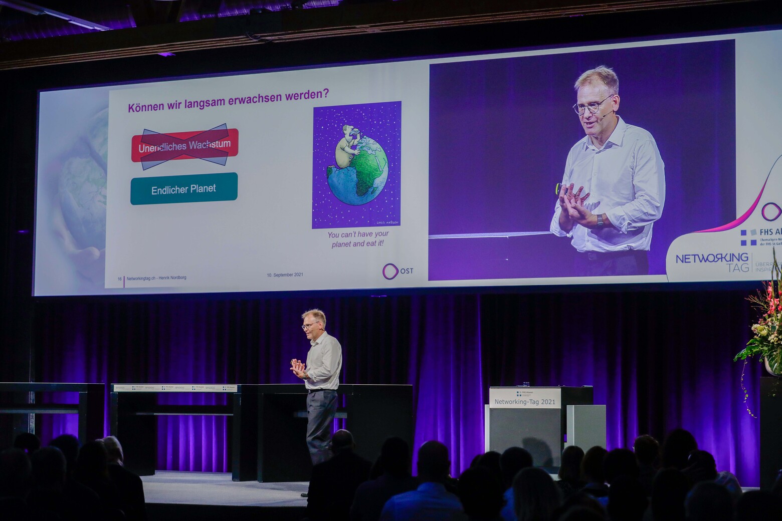 Auf der Bühne steht Prof. Dr. Henrik Nordborg, der Leiter des Studiengangs BSc Erneuerbare Energien und Umwelttechnik, und hält ein Referat.