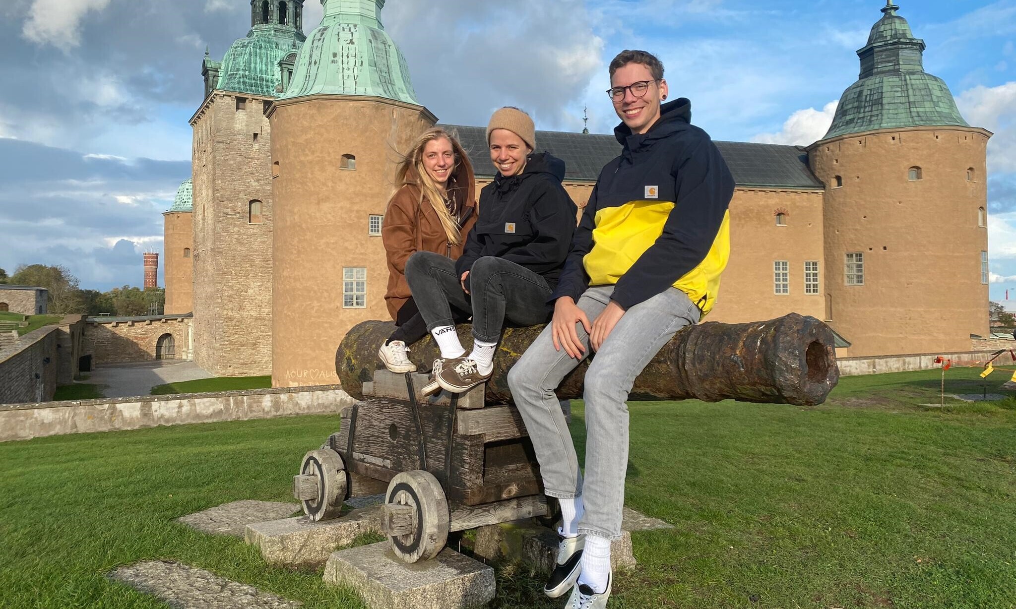 Zu sehen sind Timo Mannhart, der an der OST studiert, sowie zwei weitere Studentinnen, die vor einer Burg sitzen. 