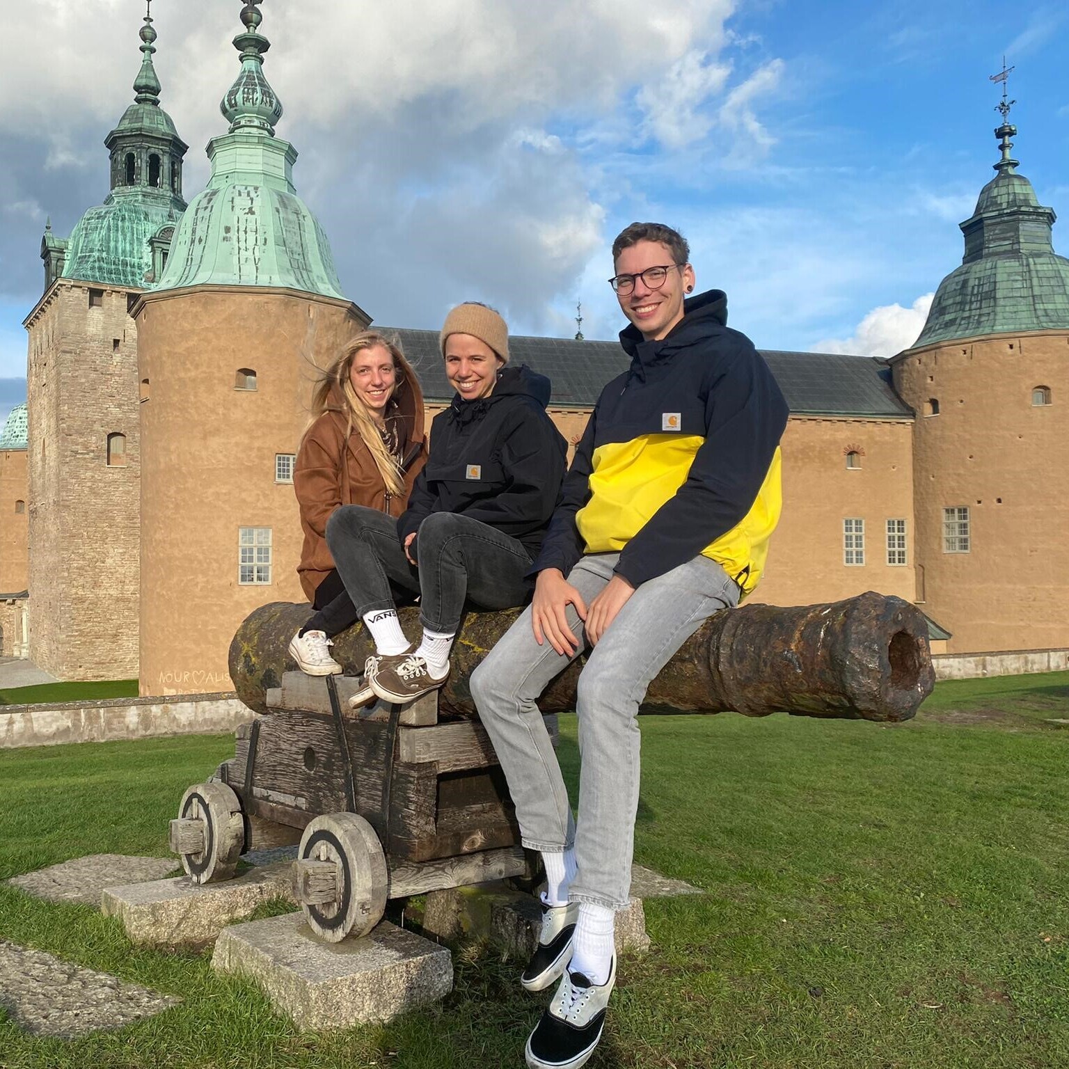 Zu sehen sind Timo Mannhart, der an der OST studiert, sowie zwei weitere Studentinnen, die vor einer Burg sitzen. 