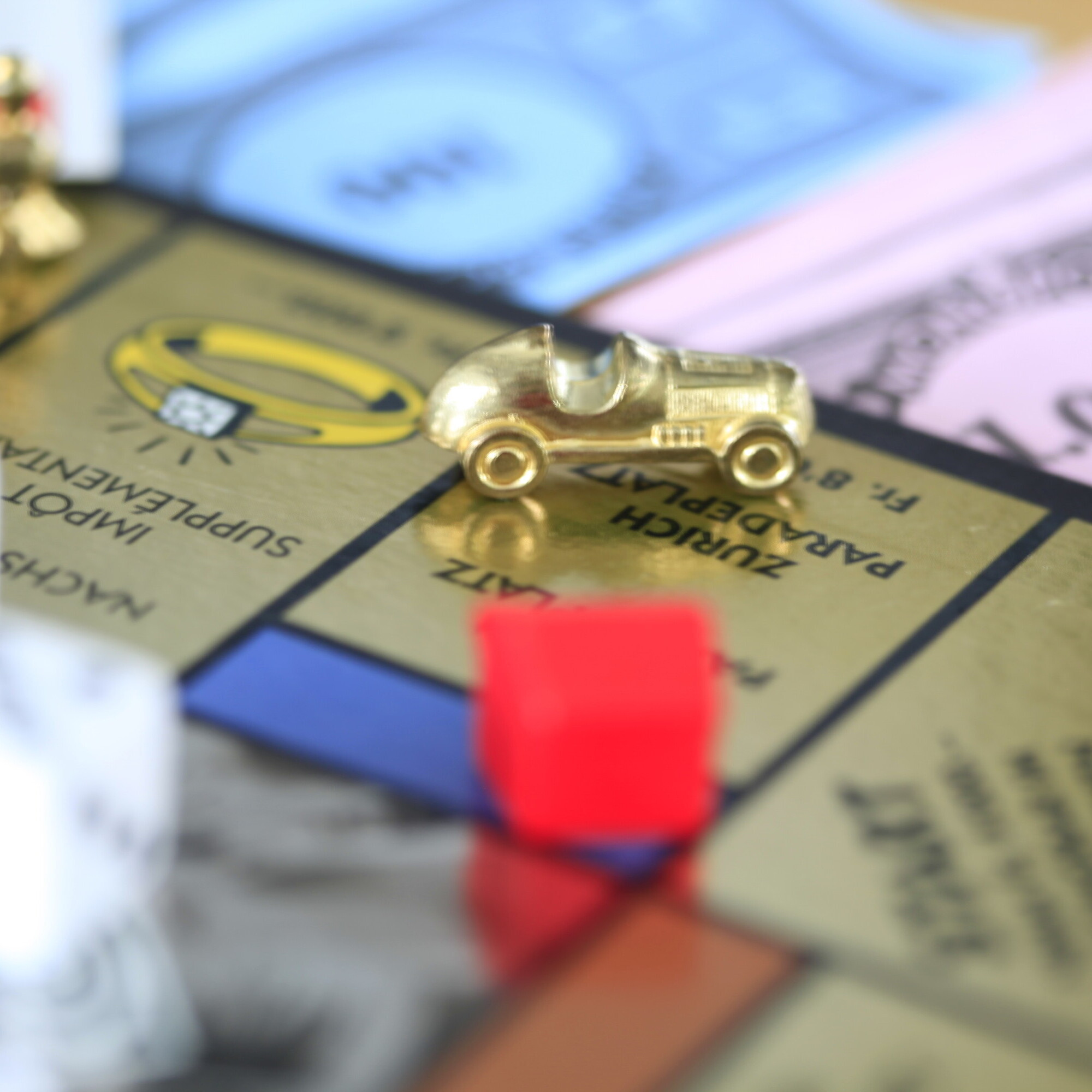 Ein goldiges Auto ist auf dem Monopoly-Feld in Nahaufnahme zu sehen.