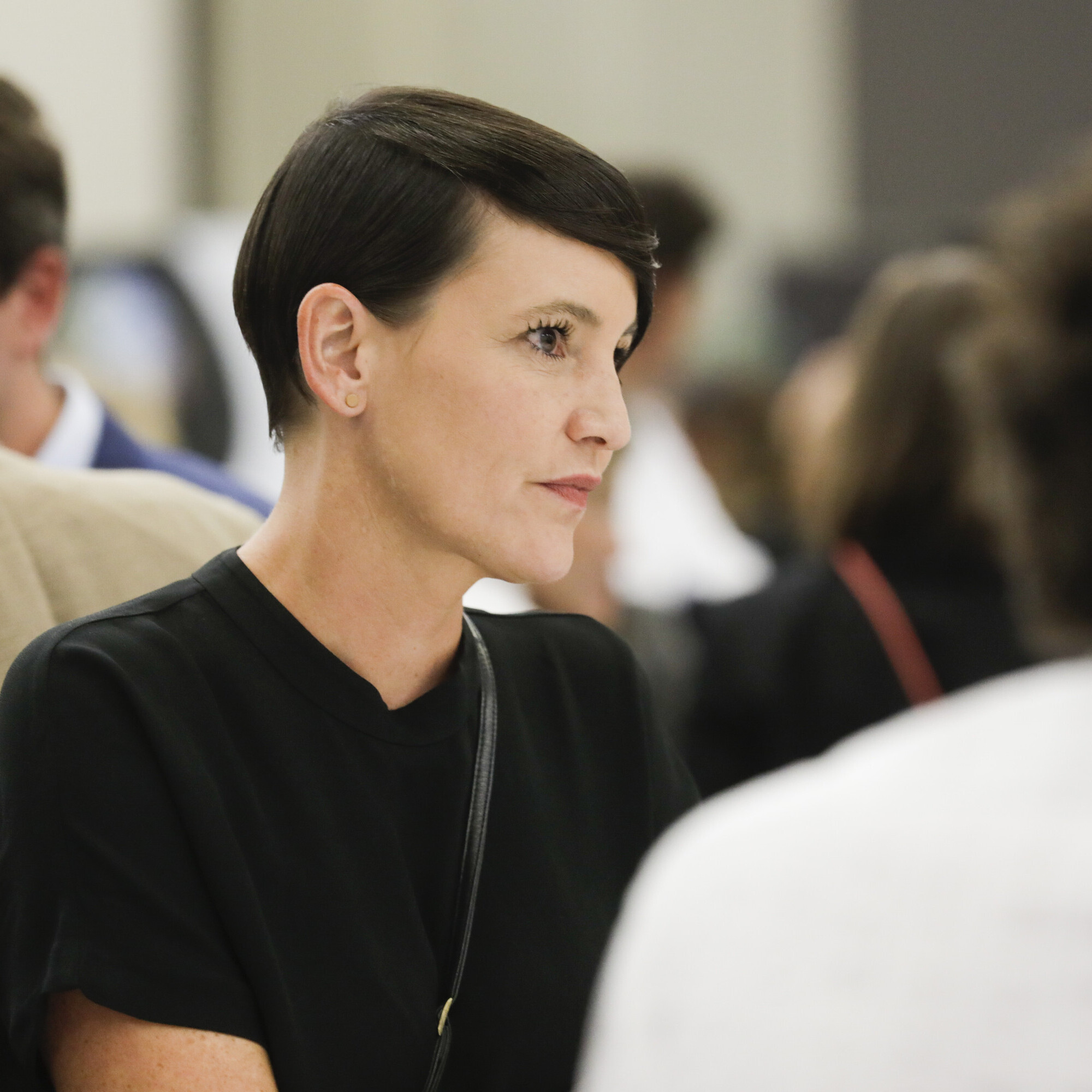 Nina Fischer, Co-Präsidentin von alumniOST, sitzt an einem Tisch mit mehreren Personen. 