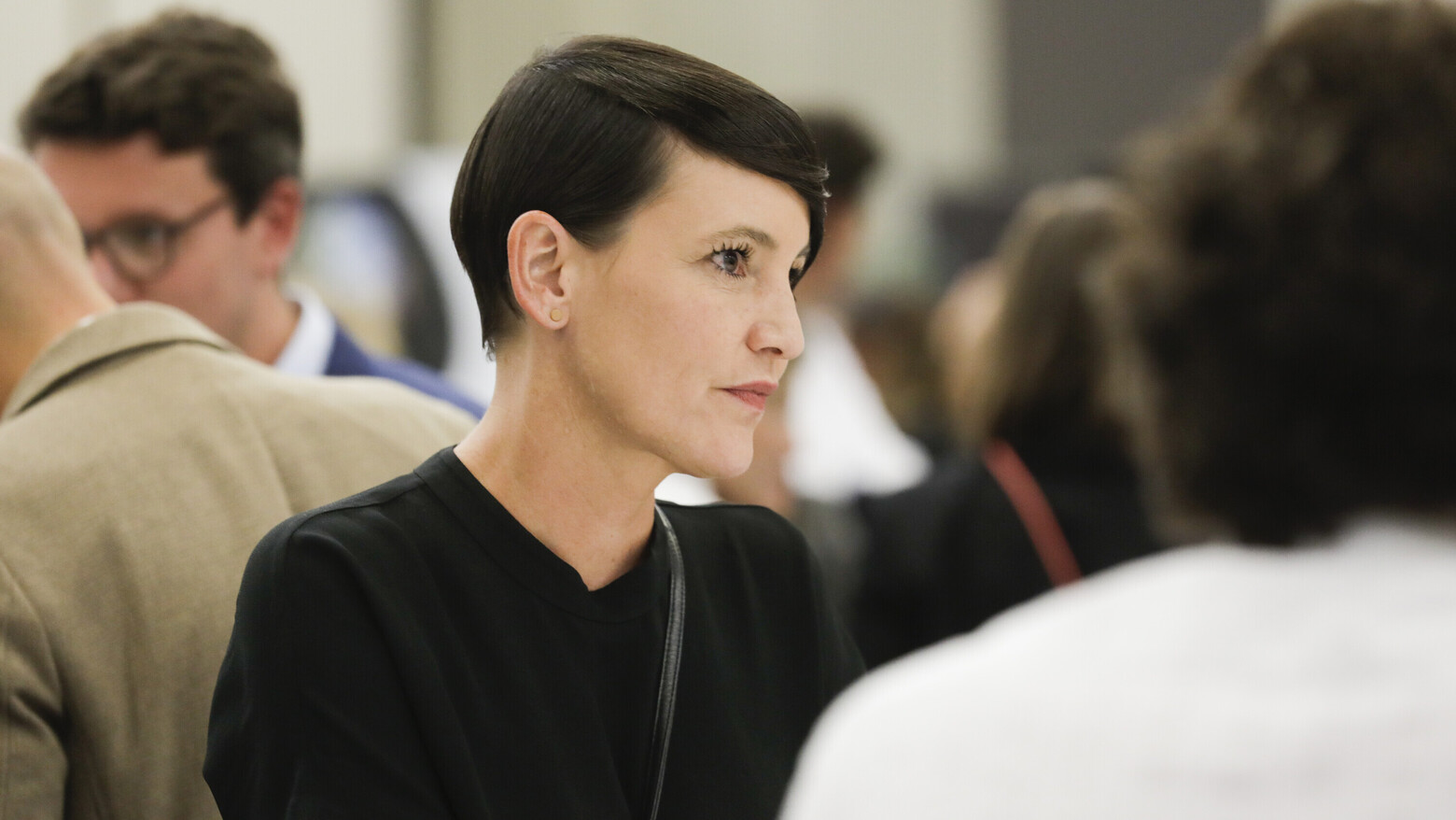 Nina Fischer, Co-Präsidentin von alumniOST, sitzt an einem Tisch mit mehreren Personen. 