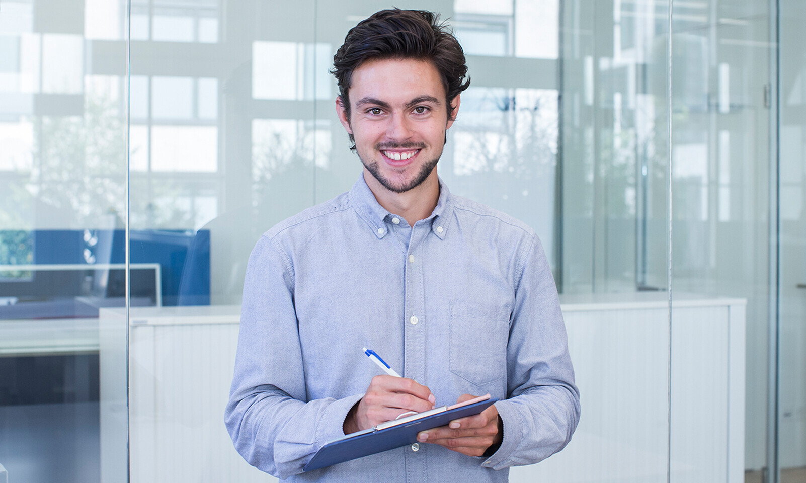 Dominik Züttel hat an der OST Wirtschaftsinformatik studiert, er hält einen Stift und ein Klemmbrett in der Hand. 