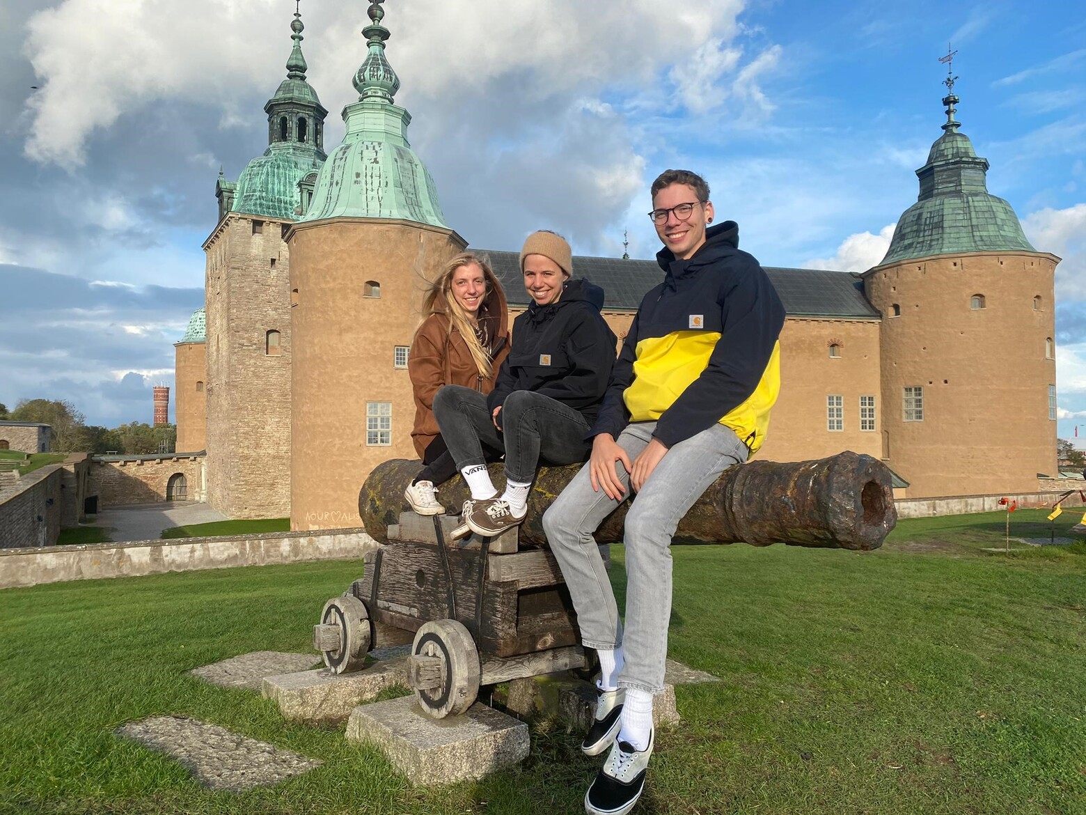 Zu sehen sind Timo Mannhart, der an der OST studiert, sowie zwei weitere Studentinnen, die vor einer Burg sitzen. 