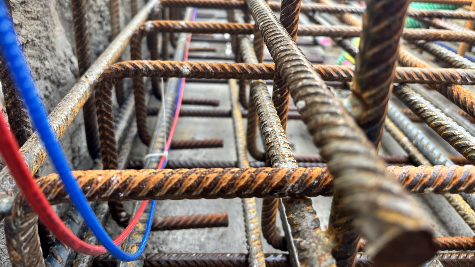 In der Bewehrung werden faseroptische Dehnungs- und Temperatursensoren in den Farben Blau und Rot installiert. Das rote Kabel misst die Temperatur, das blaue die Dehnung.