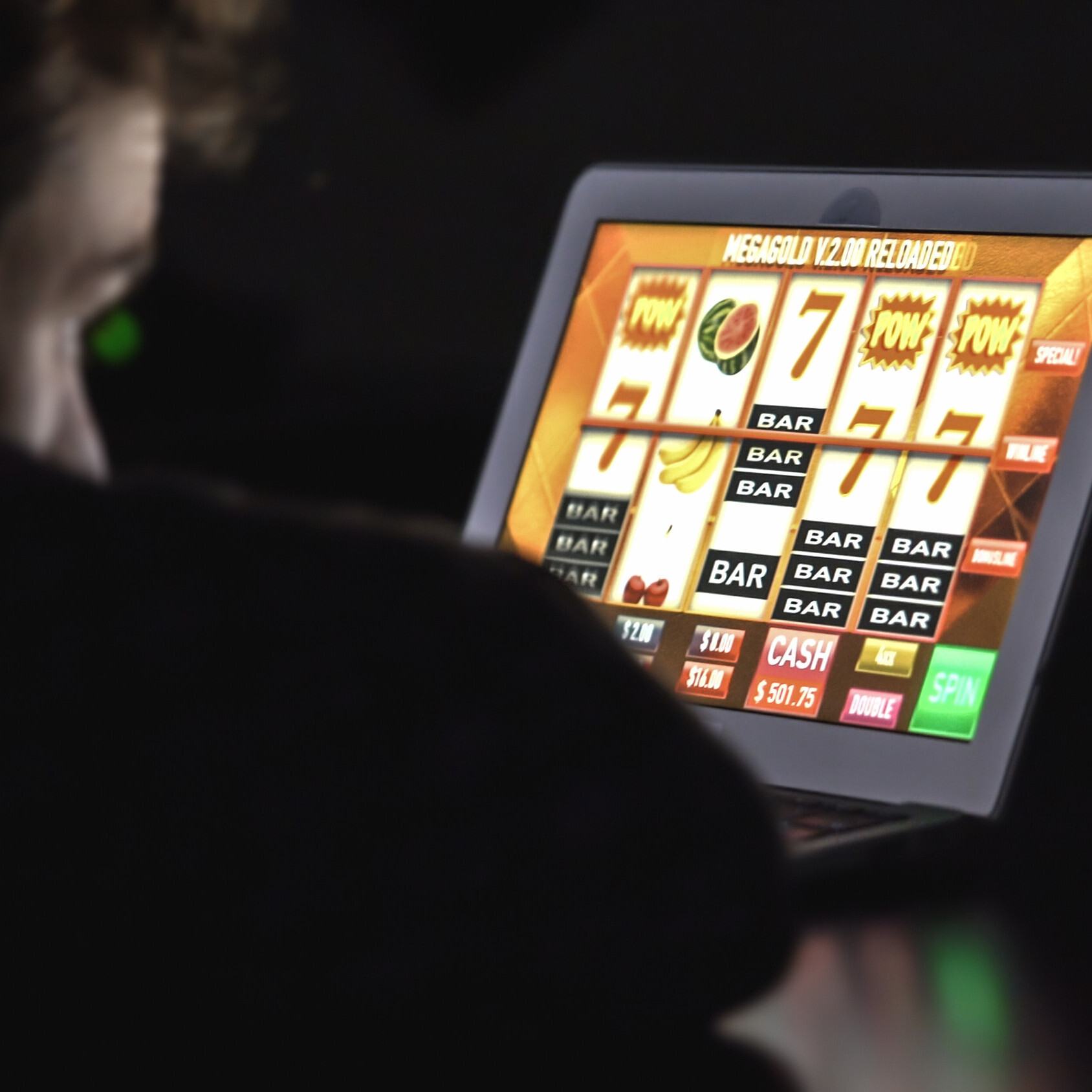 Ein junger Mann hofft auf den Jackpot im Onlinecasino auf seinem iPad.