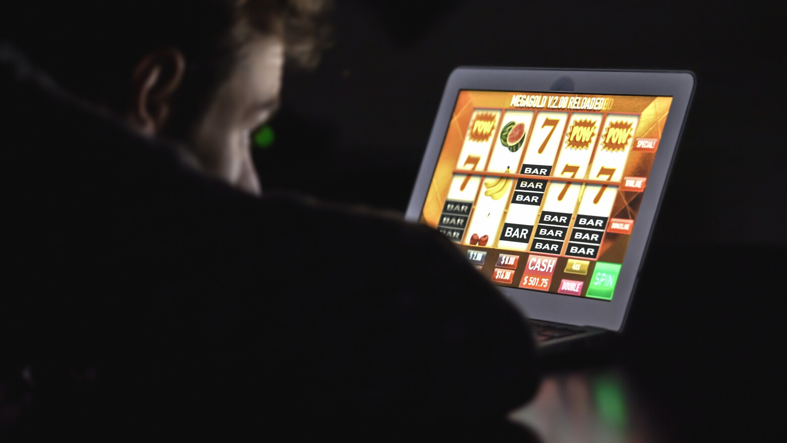 Ein junger Mann hofft auf den Jackpot im Onlinecasino auf seinem iPad.