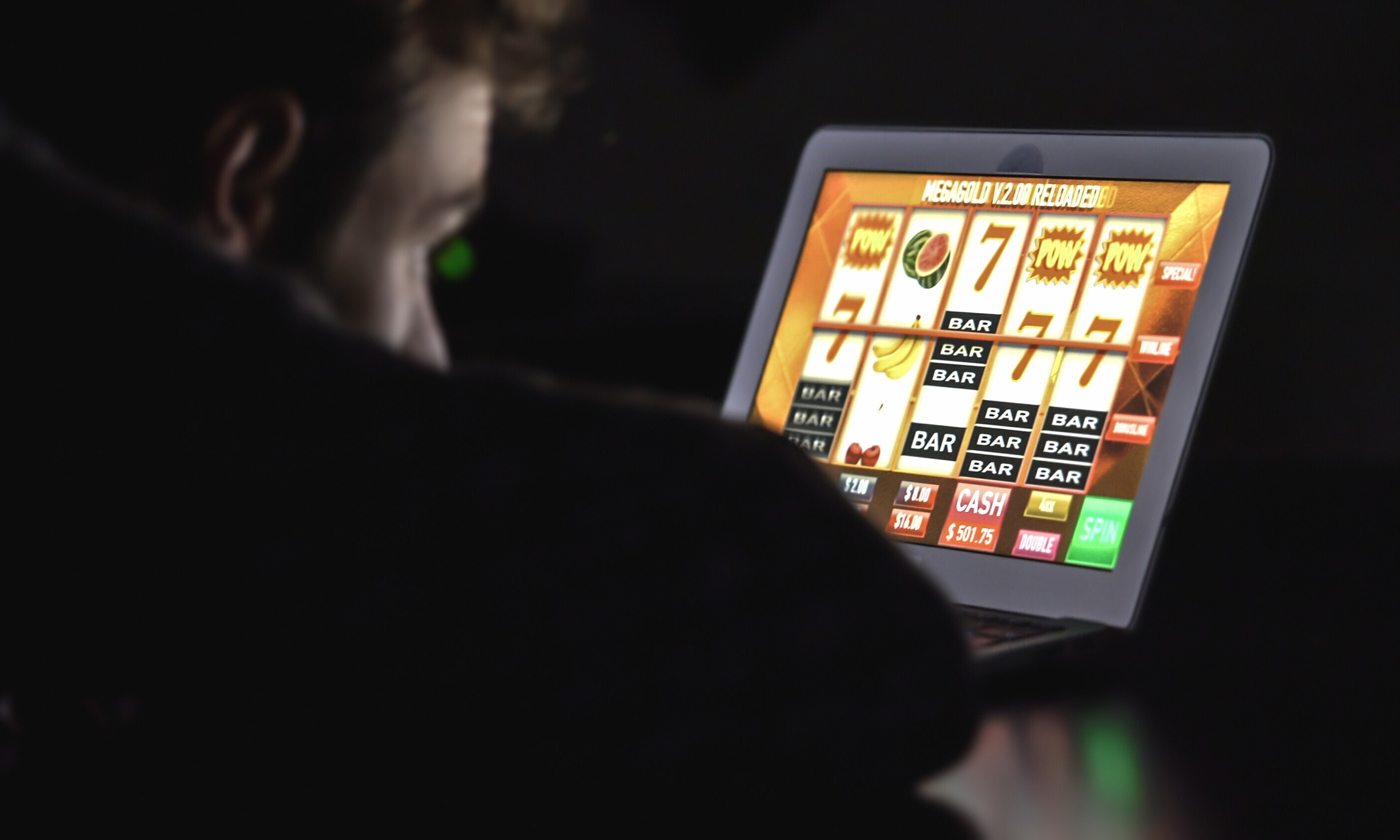 Ein junger Mann hofft auf den Jackpot im Onlinecasino auf seinem iPad.