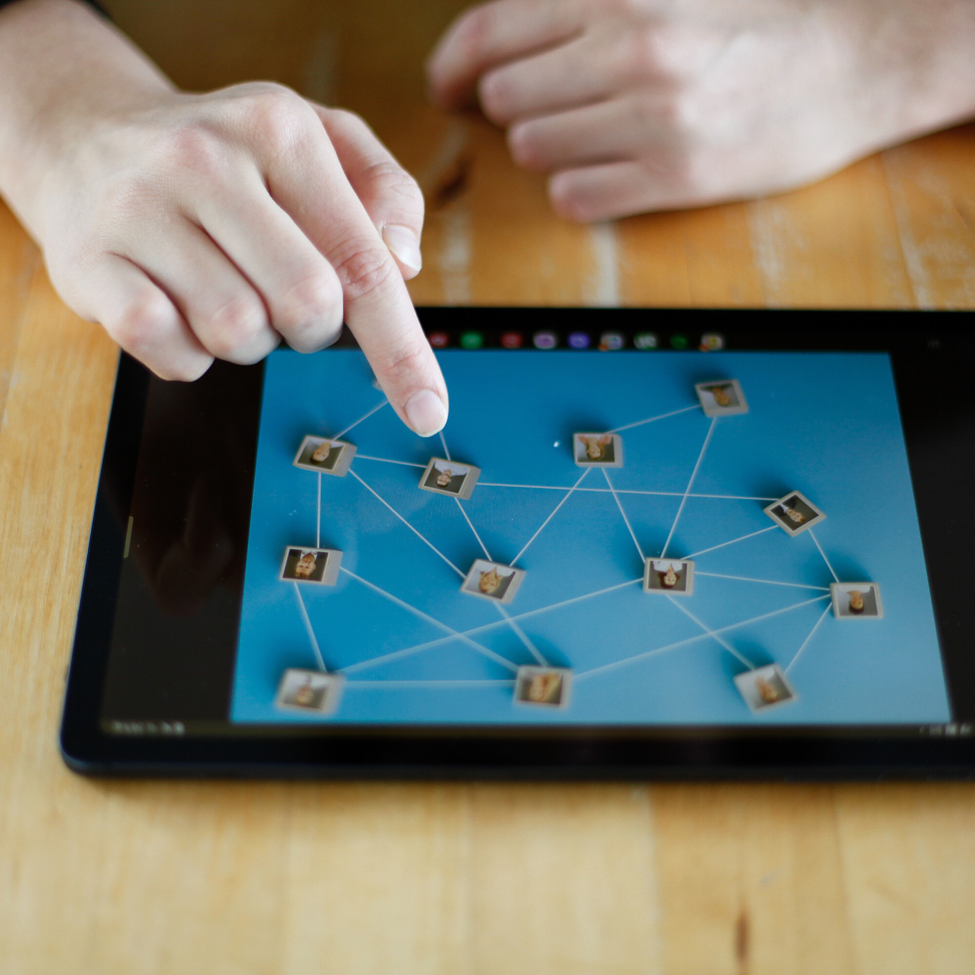 Das iPad liegt auf einem Tisch. Eine Hand tippt darauf, um die Organisationsstruktur aus HR-Sicht zu analysieren.
