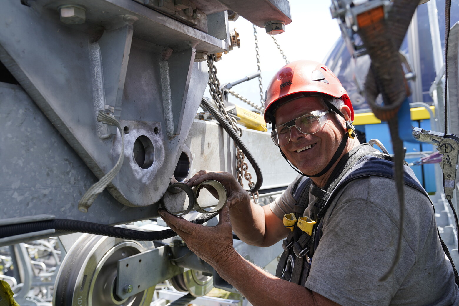 Freude bei der Arbeit: Dieser Servicetechniker zeigt die Rollen der Umlauf-Seilbahnen in die Kamera.