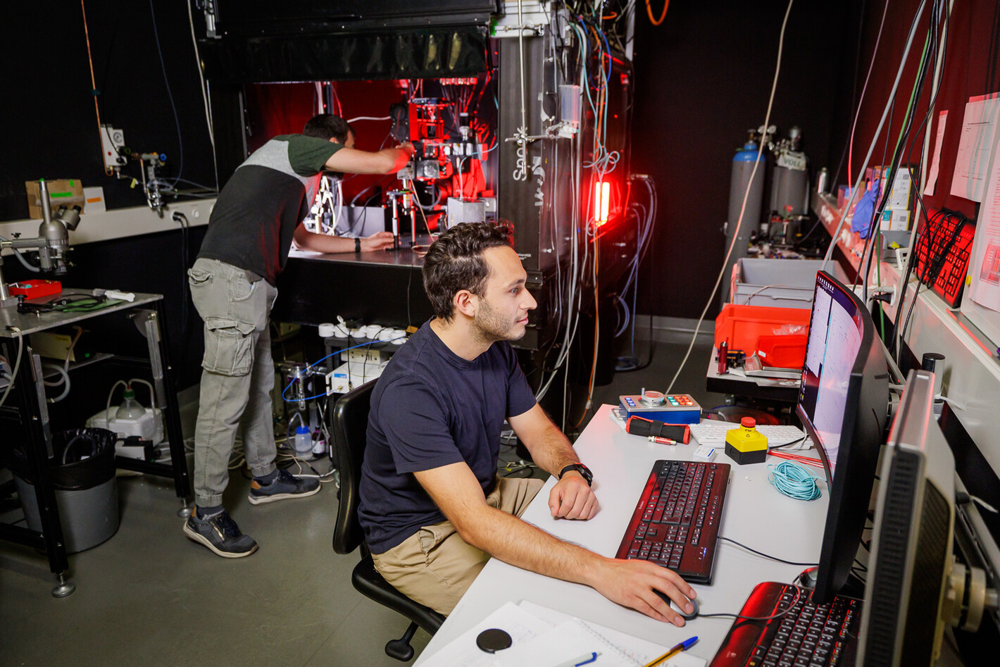 Im Labor arbeiten zwei Männer an diesem Zellmesslaser. Der eine arbeitet am Computer und der andere an der Maschine.