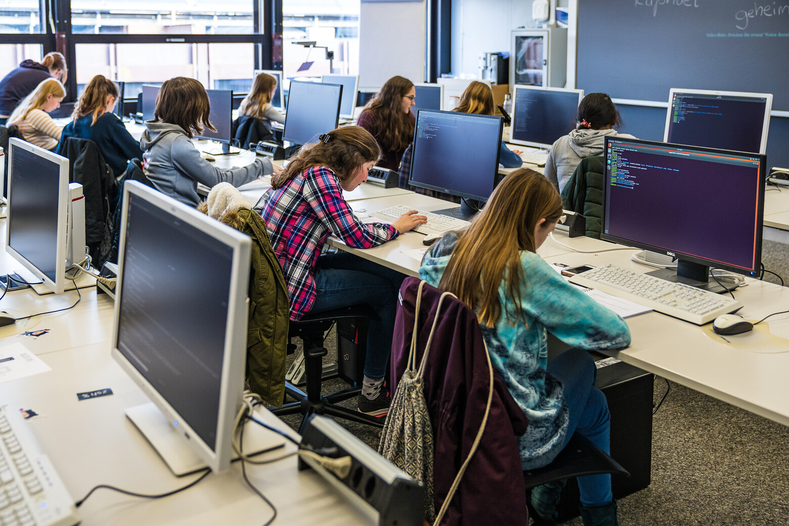 Junge Frauen sitzen konzentriert an Computern – sie interessieren sich für Informatik. 