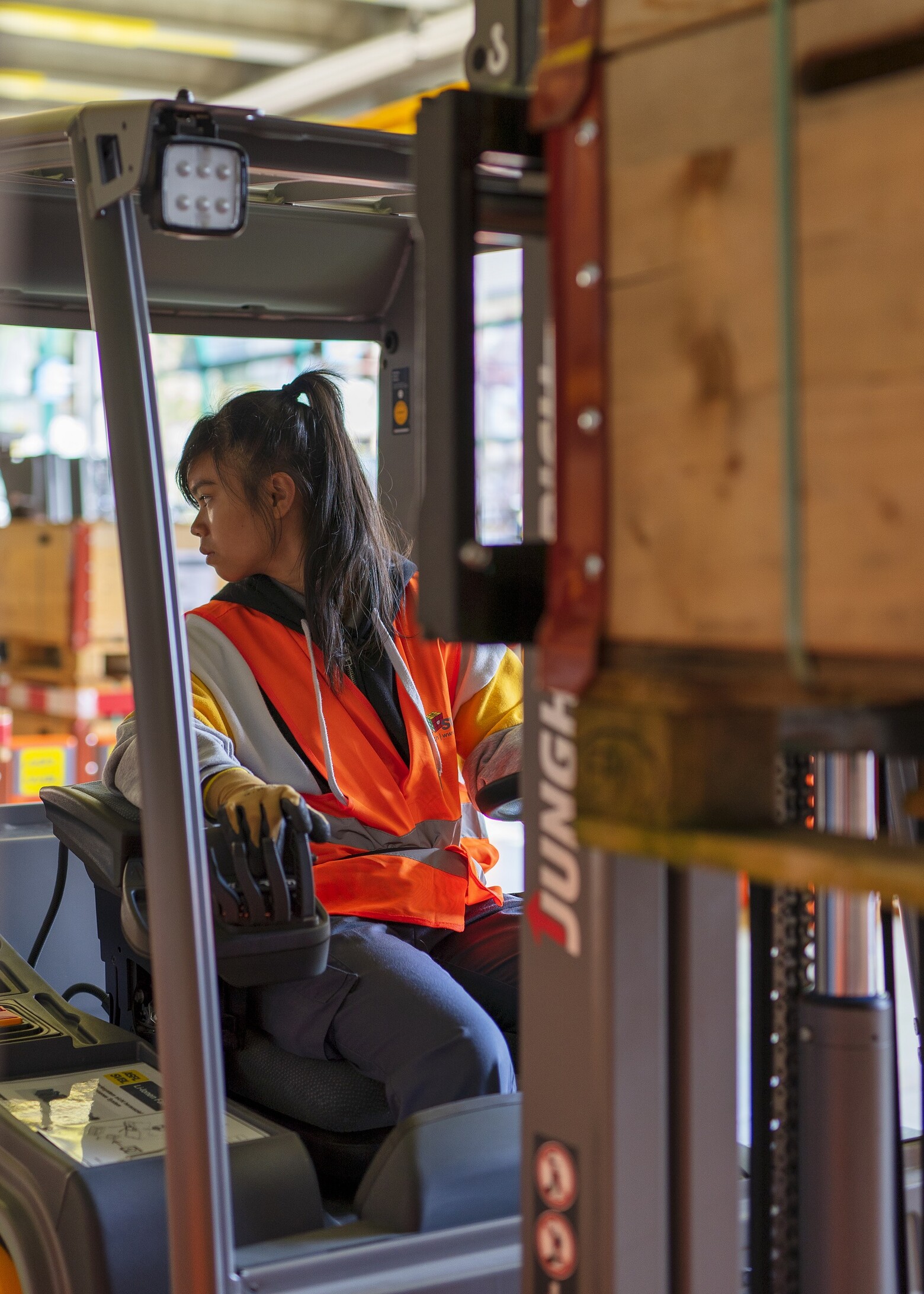  Hier ist zu sehen, wie eine Lernende sehr konzentriert mit einem Stapler rückwärts fährt.
