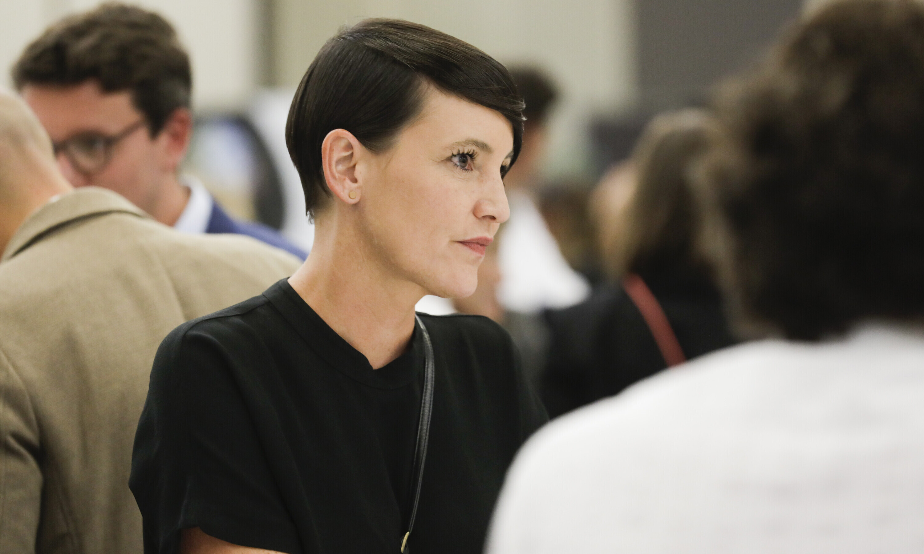 Nina Fischer, Co-Präsidentin von alumniOST, sitzt an einem Tisch mit mehreren Personen. 