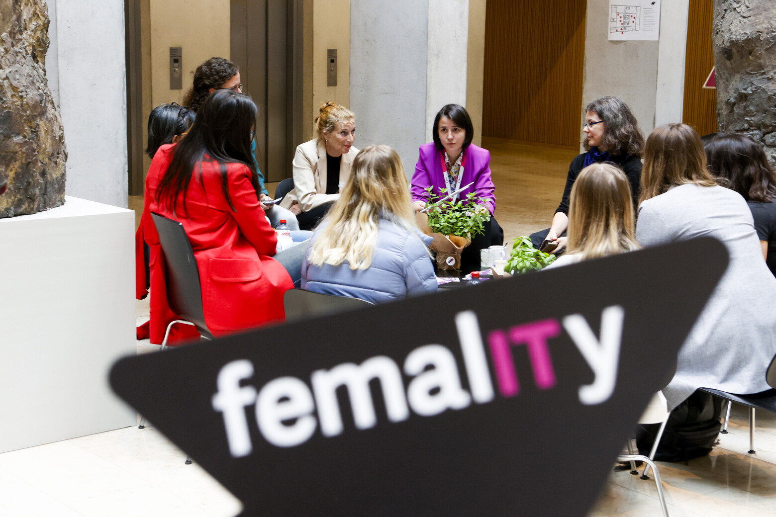 Frauen sitzen im Foyer des Fachhochschulzentrums St. Gallen, sie tauschen im Rahmen des Anlasses femalITy in Gruppendiskussionen aus.