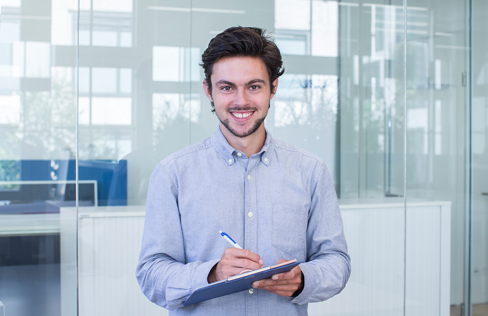 Dominik Züttel hat an der OST Wirtschaftsinformatik studiert, er hält einen Stift und ein Klemmbrett in der Hand. 