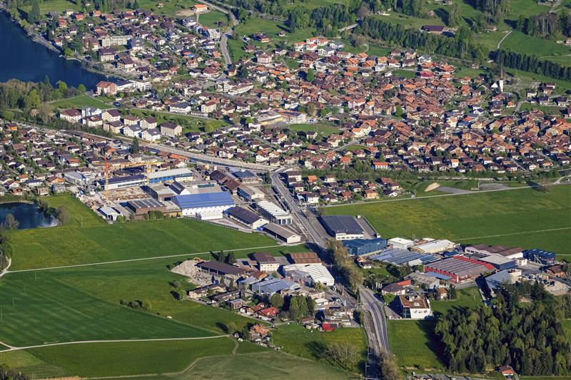 Eine an einen See grenzende Siedlung mit Industrieanlagen aus der Vogelperspektive.
