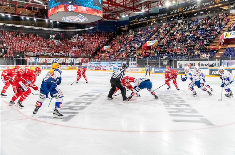 Hier ist der Eishockeyclub Rapperswil-Jona auf dem Spielfeld der vollen St.Galler Kantonalbank Arena zu sehen.